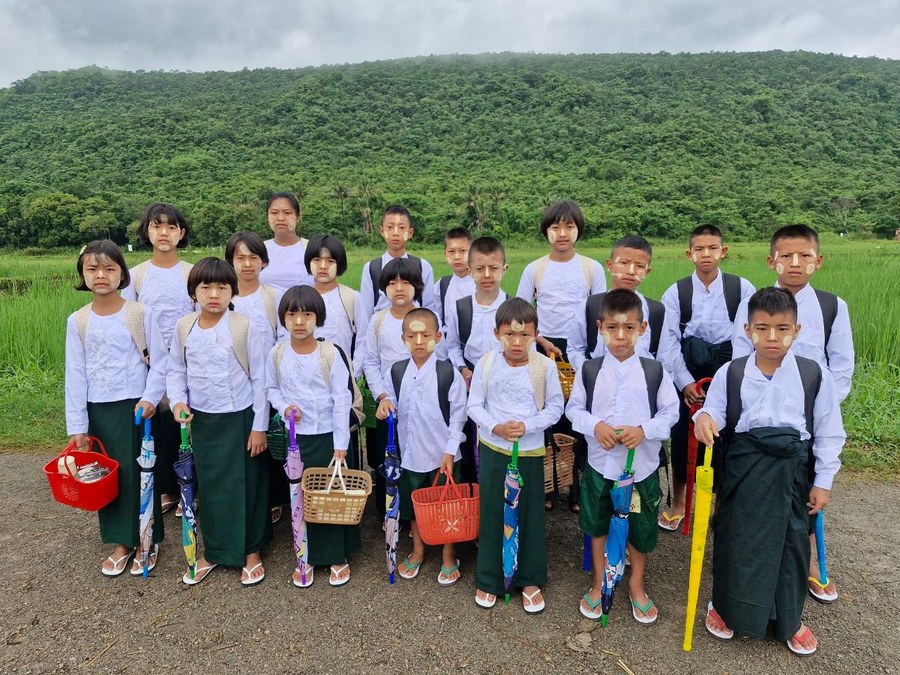 Grace Home students posing together outdoors with baskets and umbrellas